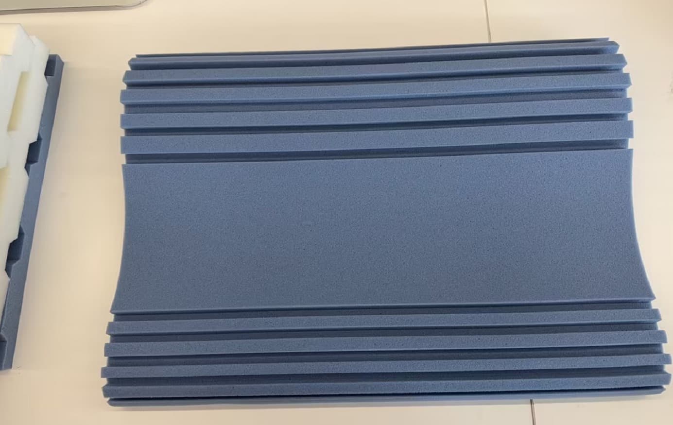 Extreme close up of the blue gel-infused slow rebound foam showing precise horizontal breathing grooves